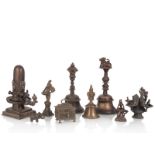 Neun Objekte aus Bronze, u.a. drei Glocken, Deckeldose, zwei Öllampen und Lingam
