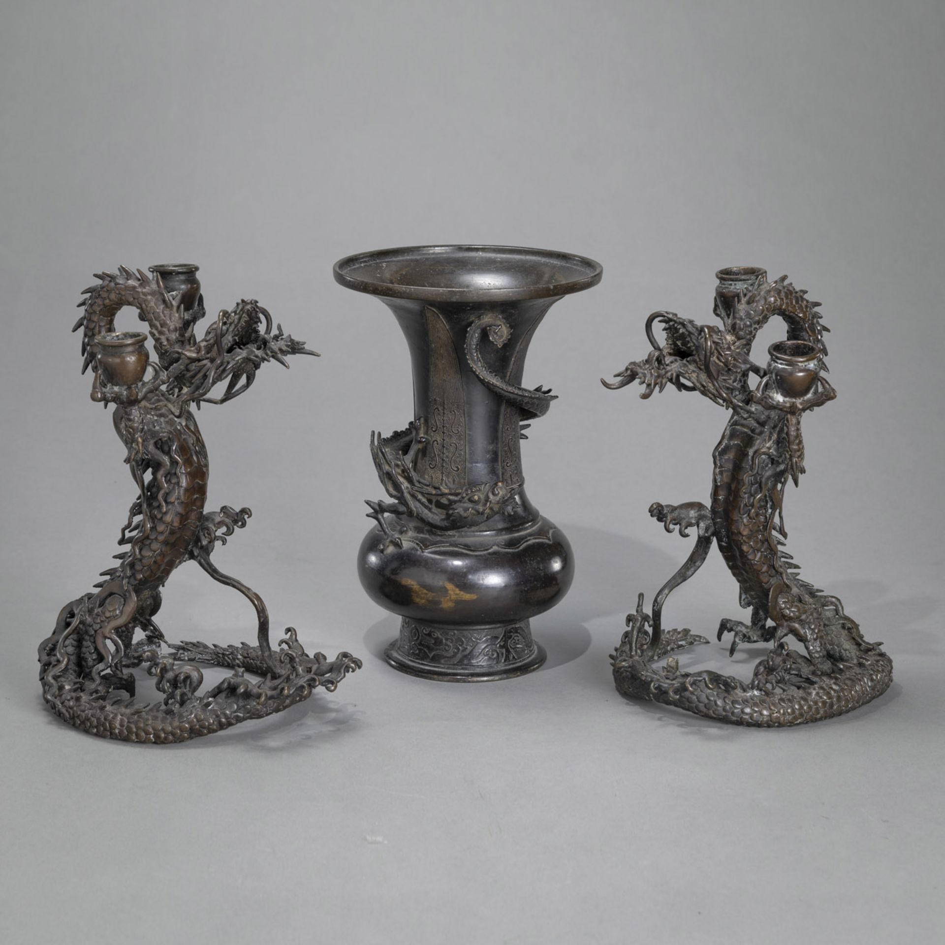 A PAIR OF DRAGON-SHAPED BRONZE CANDLESTICKS AND A BRONZE VASE WITH CURLING DRAGON
