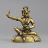 Sitzender Mahasiddha aus feuervergoldeter Bronze auf einem Sitzkissen