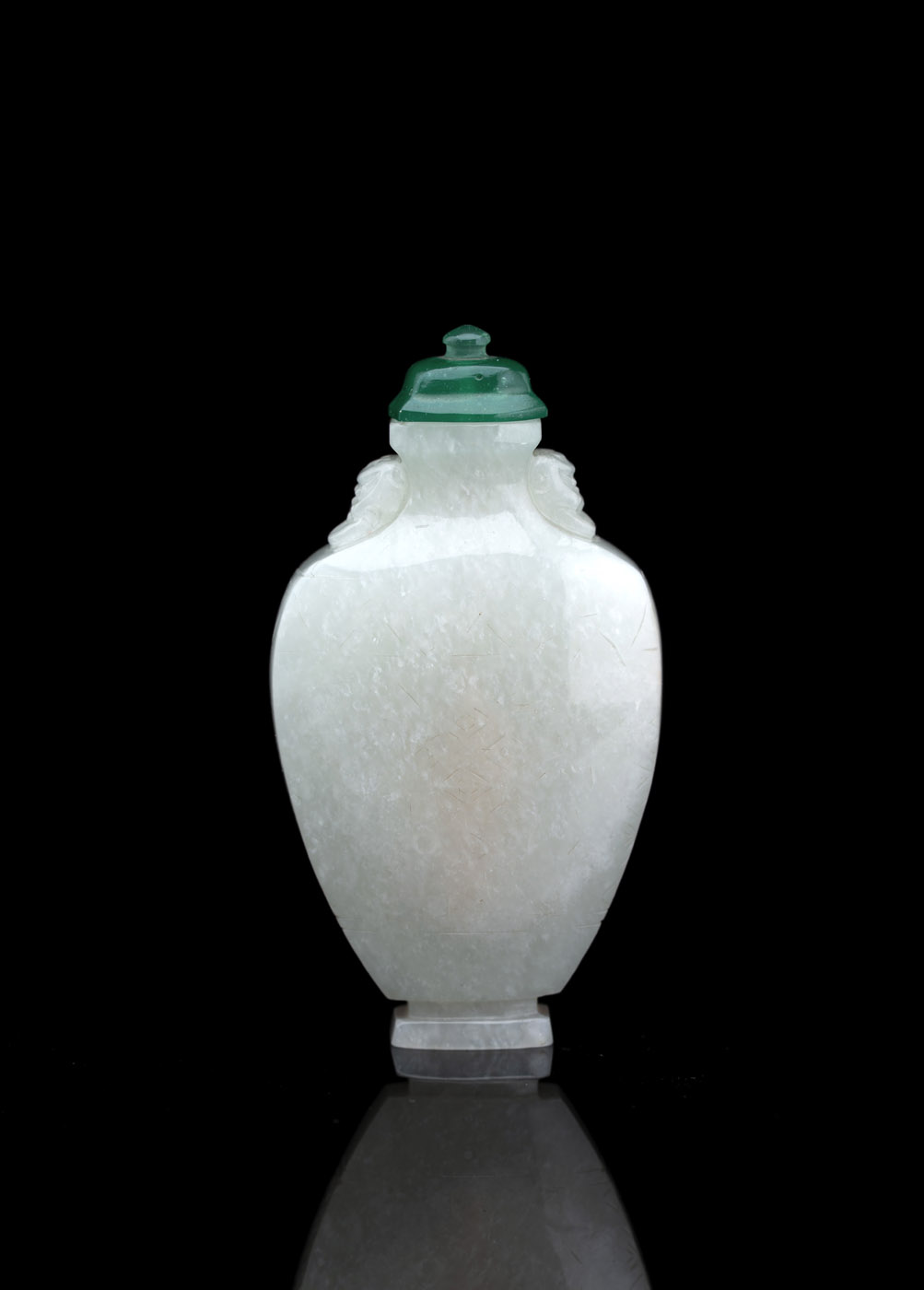 A WELL CARVED LIGHT GREEN JADE SNUFFBOTTLE WITH A GREEN GLASS STOPPER