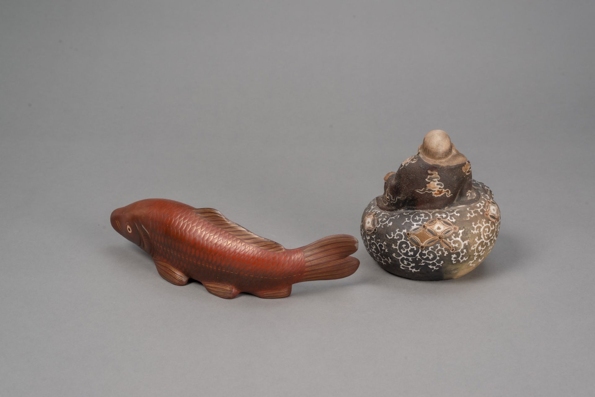 A BIZEN WARE FIGURE OF HOTEI SEATED ATOP HIS BAG AND A RED-AND GILT -LACQUERED WOOD OKIMONO OF A CA - Image 2 of 4