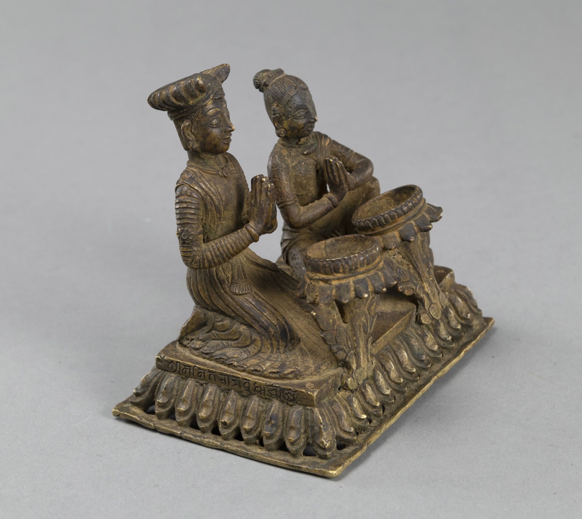 A GILT-COPPER OILLAMP WITH A KNEELING WORSHIPPING COUPLE ON A RECTANGULAR LOTUS BASE - Image 2 of 4