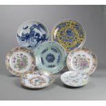 Gruppe von sieben blau-weiß und polychrom dekorierten Porzellantellern