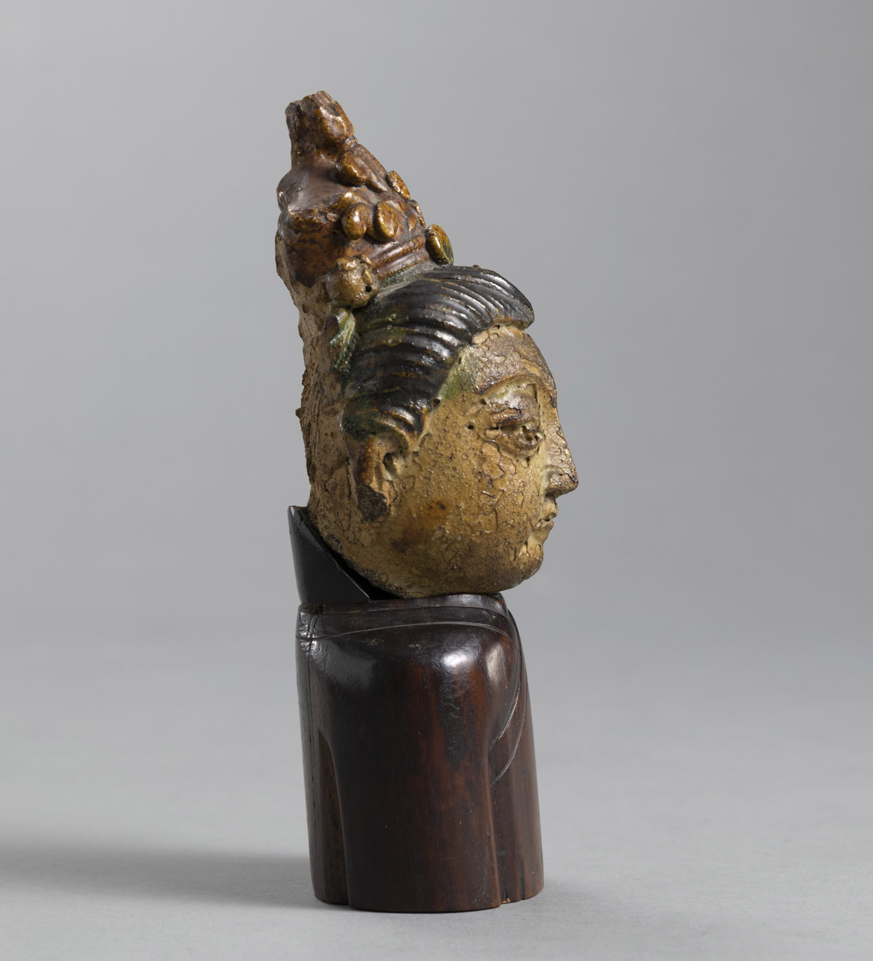 A SMALL PARTLY PAINTED TERRACOTTA GUANYIN HEAD ON A WOOD STAND IN THE FORM OF A TORSO - Image 2 of 4