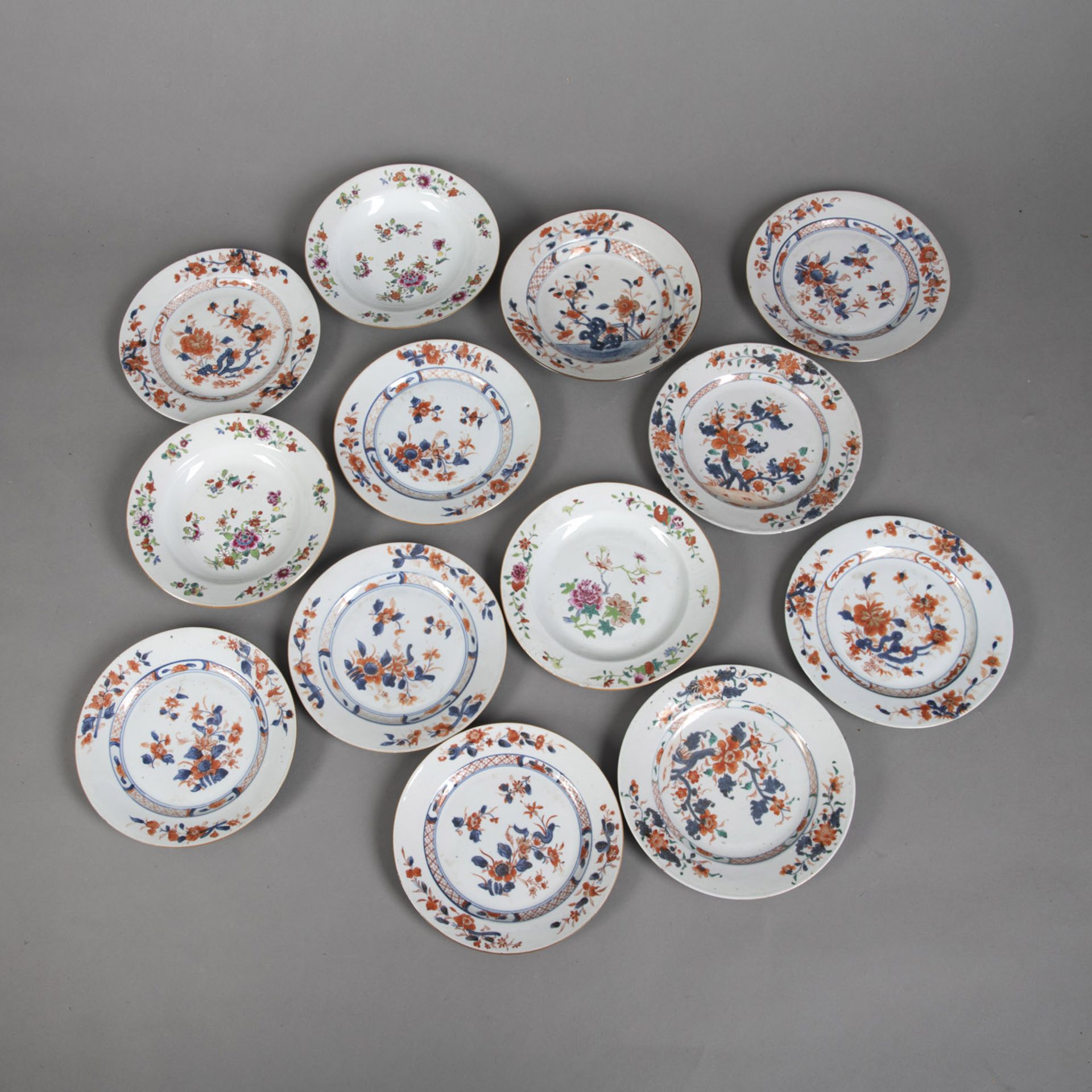 13 EXPORT PORCELAIN PLATES PAINTED IN 'FAMILLE ROSE' AND UNDERGLAZE BLUE, PARTLY WITH GOLD, WITH FL