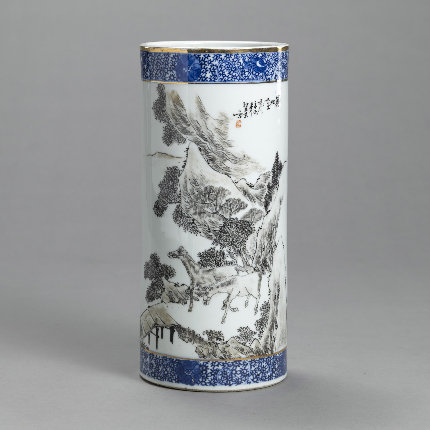 A CYLINDRICAL PORCELAIN HAT STAND WITH GRISAILLE PAINTED LANDSCAPE WITH TWO HORSES