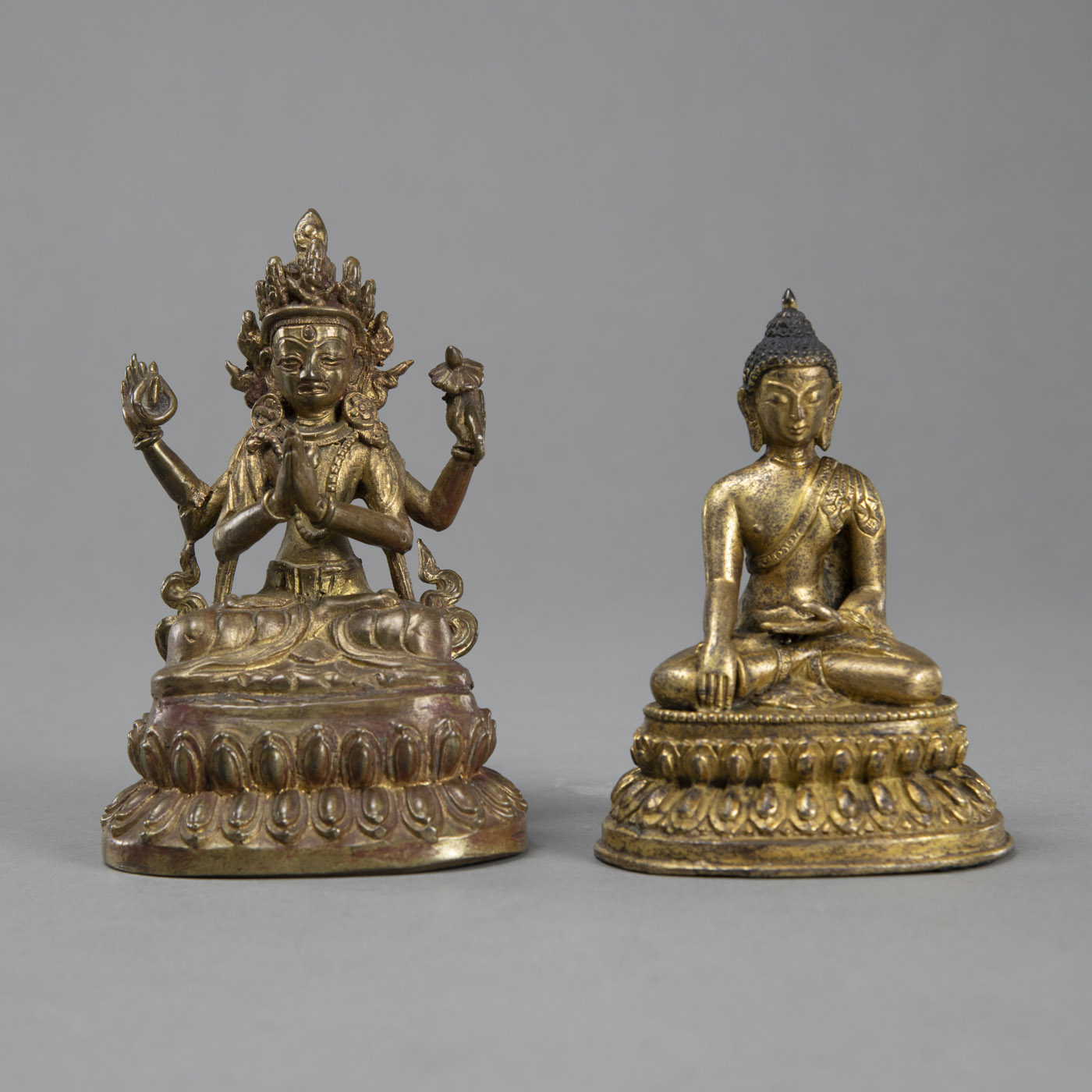 A GILT BRONZE SEATED BUDDHA SHAKYAMUNI AND A LACQUERED AND GILT BRONZE FIGURE OF FOUR-ARMED AVALOKI