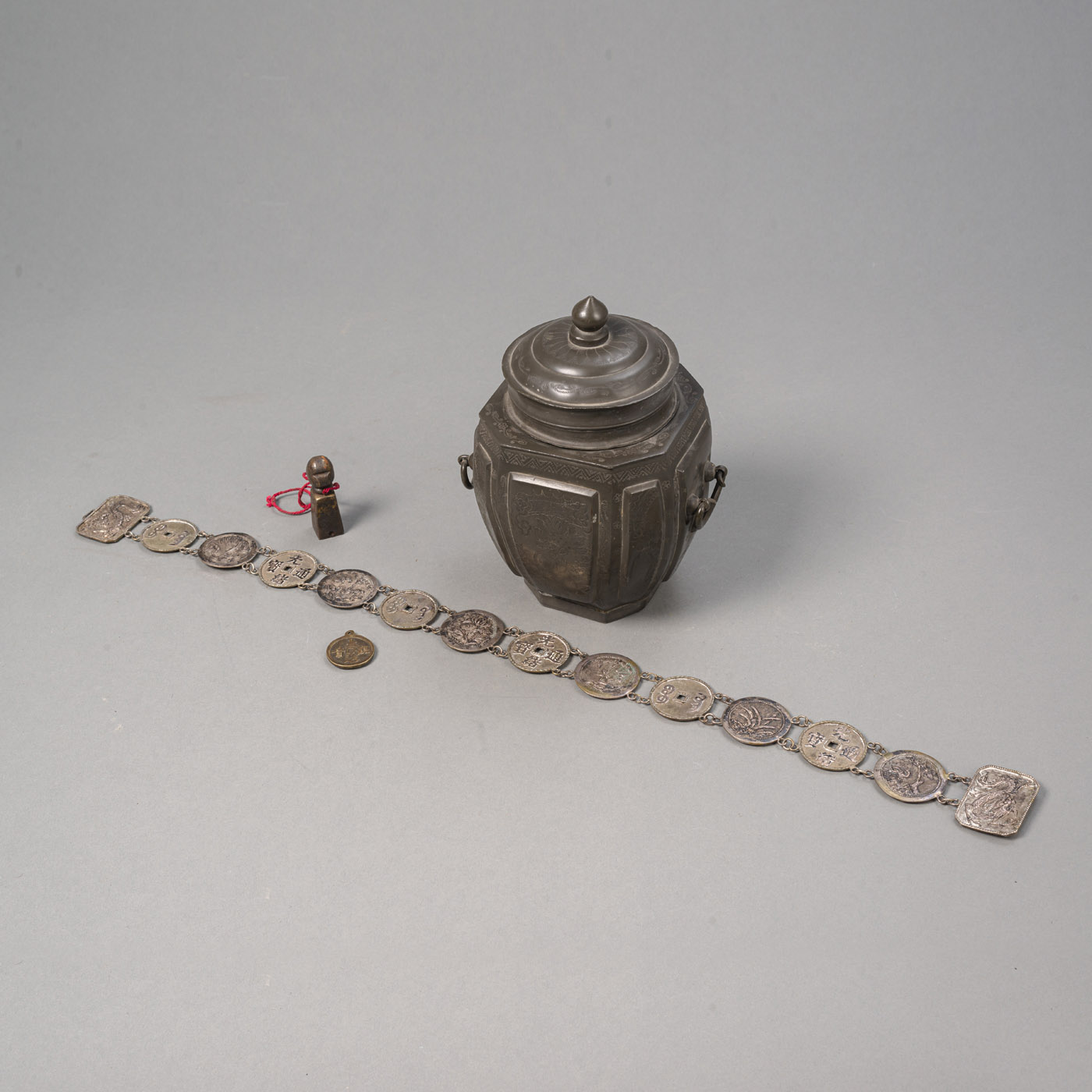 A PEWTER BOX AND COVER, A COIN SILVER PLATE BELT, A MEDALLION PENDANT AND A SEAL