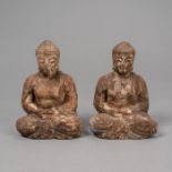 Zwei Figuren des Buddha aus Holz mit Resten von Fassung