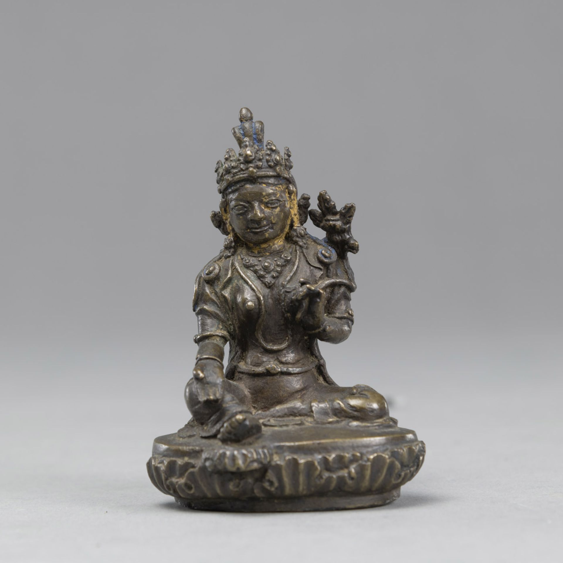 A SMALL BRONZE SEATED GREEN TARA