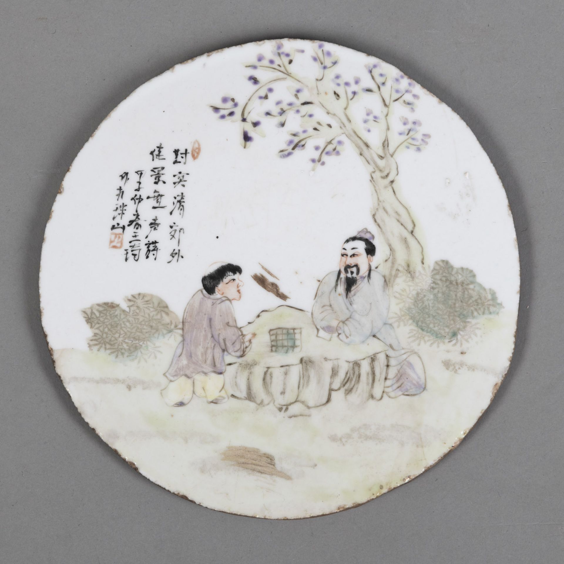 A POLYCHROME PAINTED ROUND PORCELAIN TILE DEPICTING SCHOLARS AT GO GAME