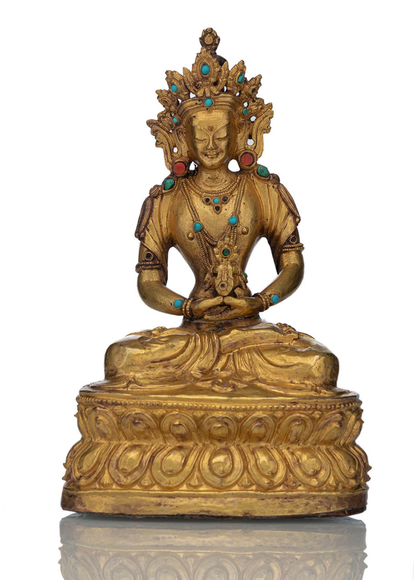 A GILT-BRONZE AND REPOUSSÉ FIGURE OF AMITAYUS SEATED ON A LOTUS WITH STONE INLAYS