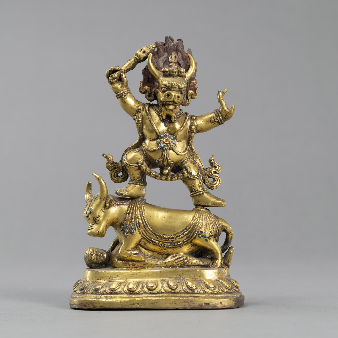 A GILT BRONZE YAMA ON A BULL, PARTIALLY PAINTED AND STONE INLAID