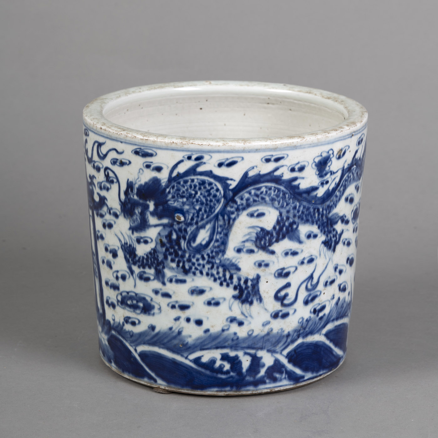 A BLUE AND WHITE PORCELAIN CACHEPOT DEPICTING A SHRINE SURROUNDED BY TWO DRAGONS