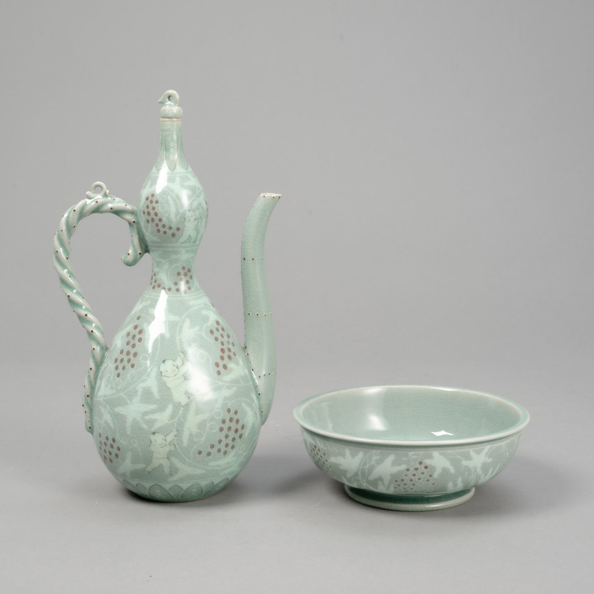 YU GEUN-HYEONG (1894-1993) - AN INLAID CELADON 'BOYS' EWER WITH BASIN