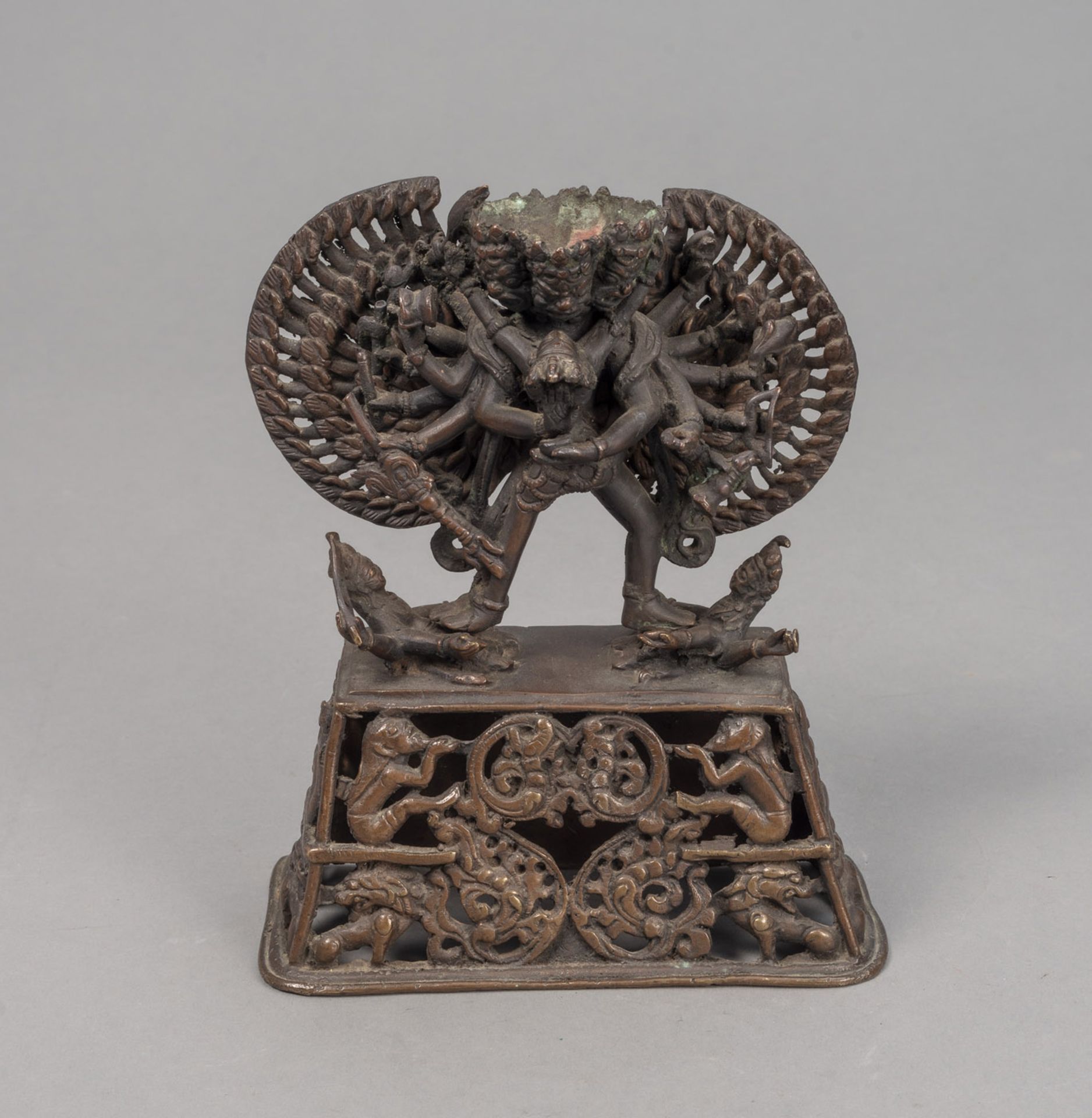 A BRONZE FIGURE OF A TANTRIC DEITY IN YAB-YUM ON AN OPENWORK PEDESTAL