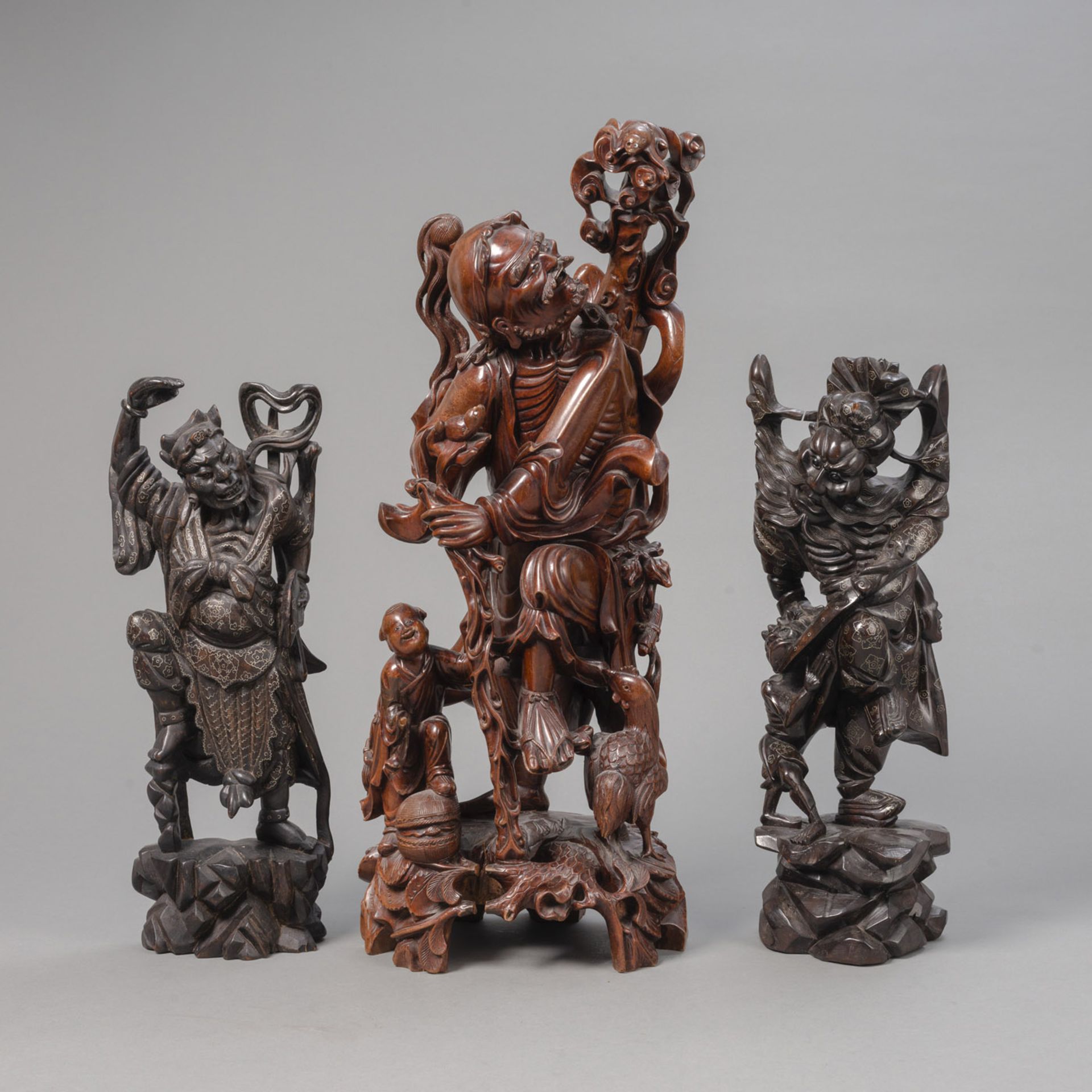 THREE WOOD CARVINGS OF TAOIST FIGURES, INCLUDING LI TIEGUAI AND ZHONG KUI, PARTLY INLAID WITH METAL