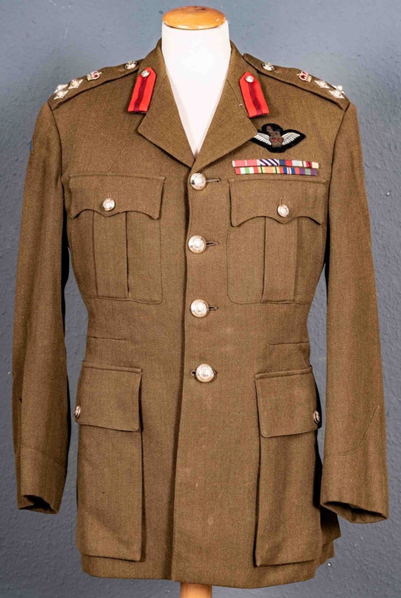 Uniformjacke eines britischen Offiziers, khaki-farbig mit diversen Schulterstückabzeichen, Kragensp