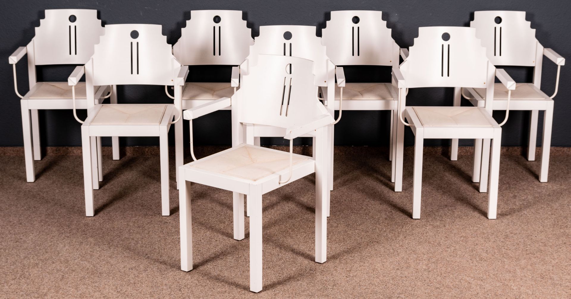 Folge von 8 Armlehnstühlen, weiß lackierte Holzgestelle in nicht alltäglicher Formgebung. Ende 20.