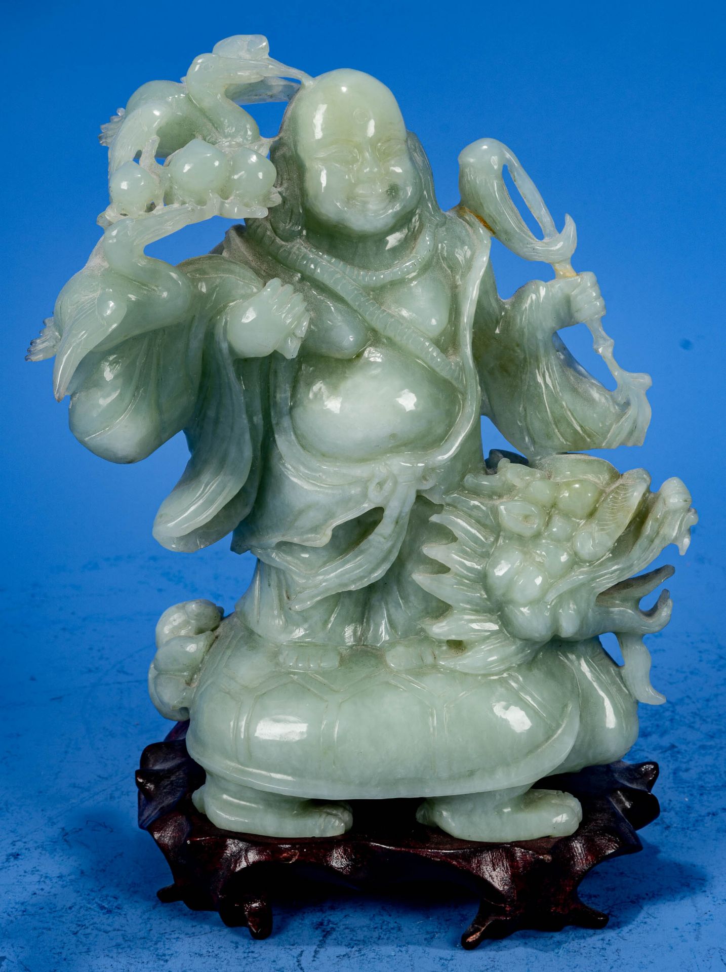 "Buddha auf Drachenkopf-Schildkröte", aus hellgrüner Jade gearbeitete, stehende Figur auf hölzernem