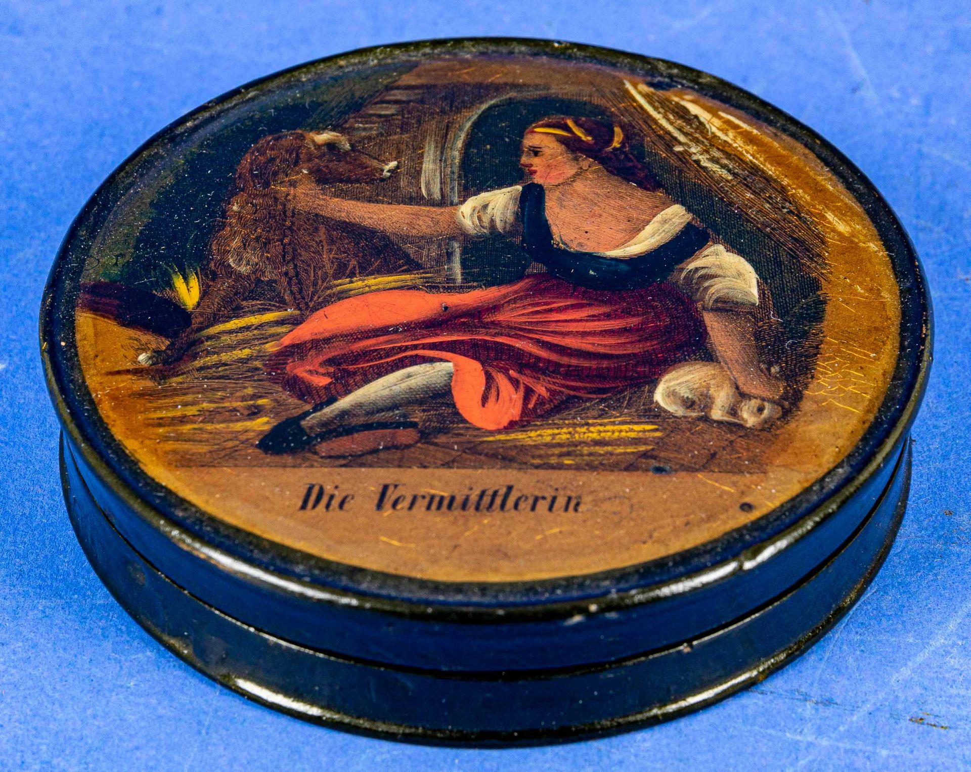"Die Vermittlerin", flache, runde Deckeldose mit polychrom lithografiertem Deckelbild. Durchmesser 