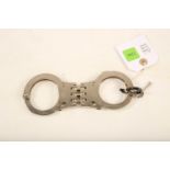 A pair of Hiatt stainless handcuffs; 18cm long; complete with key Reserve: £40 #1243