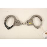A pair of Chubb stainless steel handcuffs; 28cm long Reserve: £30 #1250 #1250