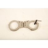 A pair of Hiatt stainless handcuffs; 18cm long; complete with key Reserve: £40 #1244
