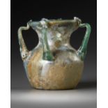 A ROMAN FOUR-HANDLED GREEN GLASS JAR, CIRCA 3RD CENTURY A.D.