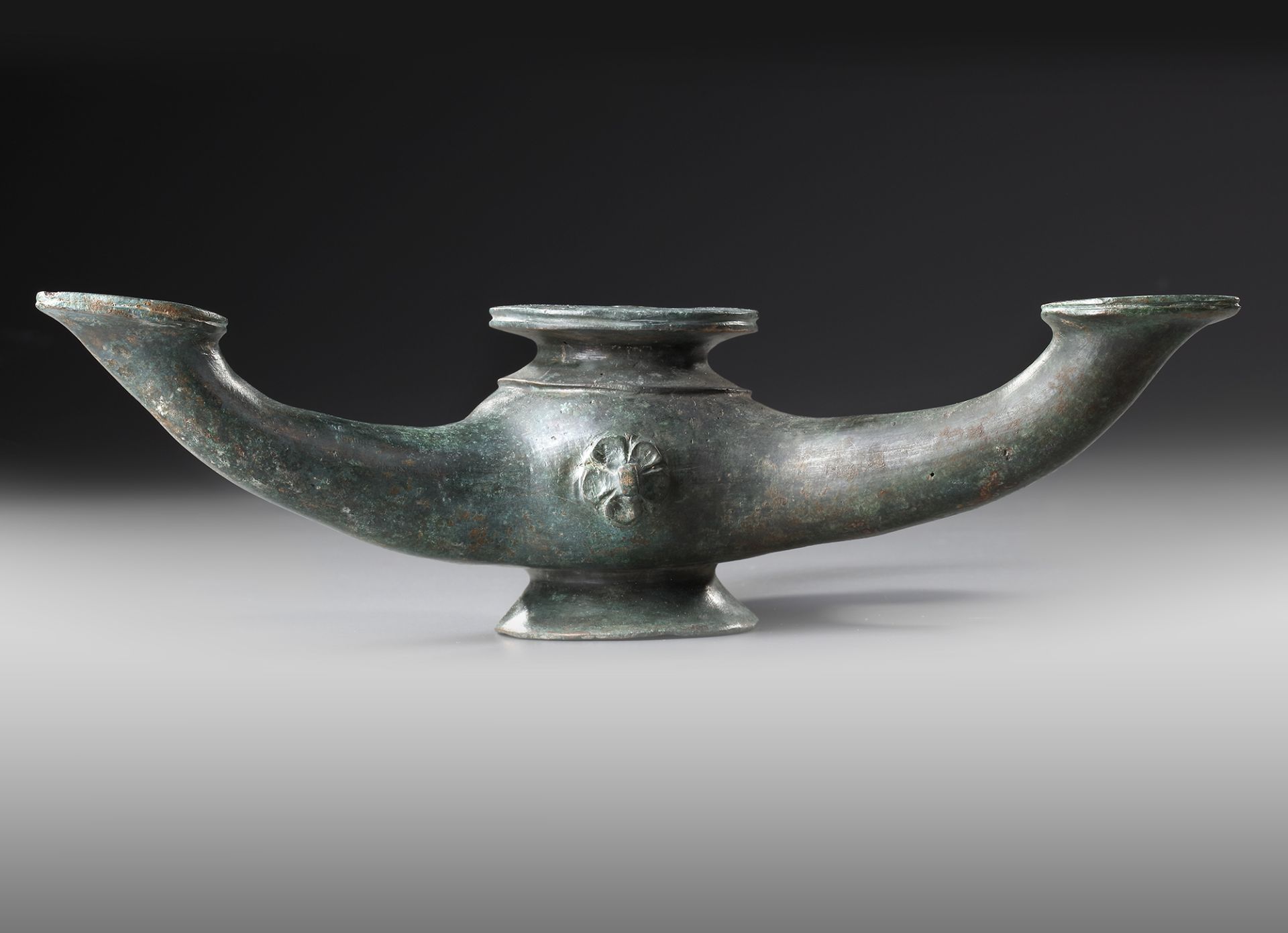 A BYZANTINE THREE -SPOUTED BRONZE OIL LAMP, CIRCA 4TH-5TH CENTURY A.D.