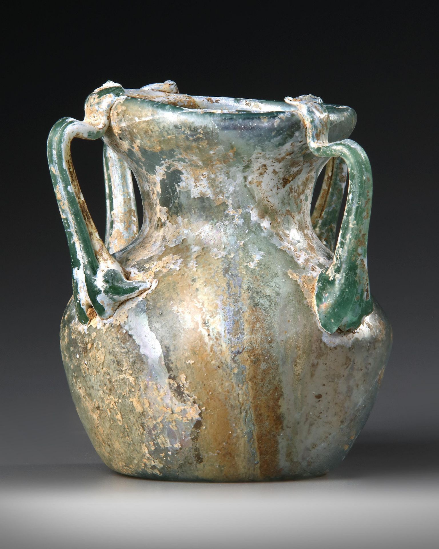 A ROMAN FOUR-HANDLED GREEN GLASS JAR, CIRCA 3RD CENTURY A.D. - Image 2 of 4
