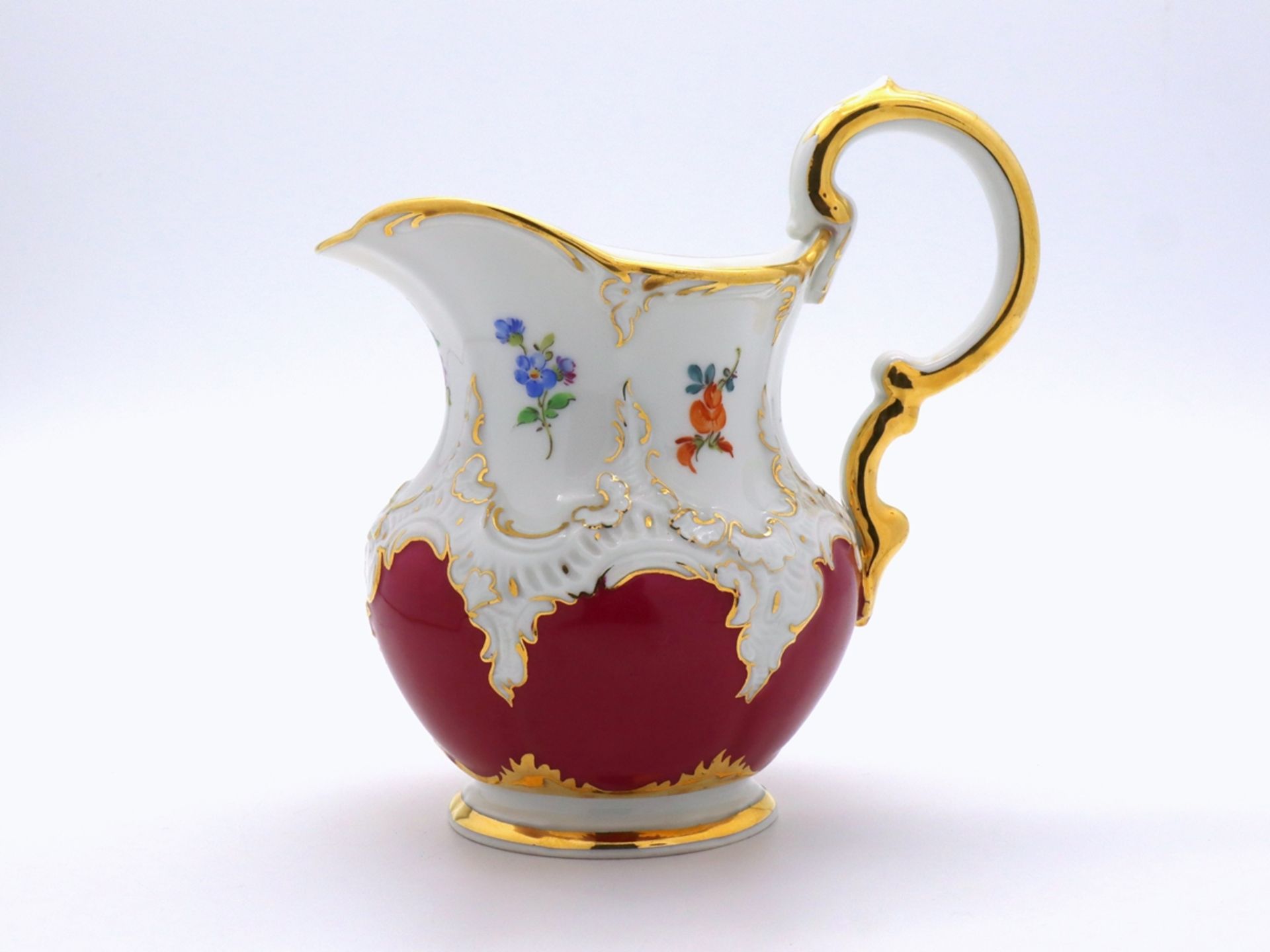 Meissen splendour cream jug, B-form in noble purple with scattered flowers, after 1945.