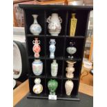 Collection of oriental vases in fitted cabinet.