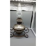 Early 1900s oil lamp on stand .