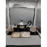 3 piece silver plated tea set together with silver plated dutch scene dishes .
