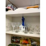 Shelf of crystal includes baby sham retro glasses , welsch porcelain tea pot etc .