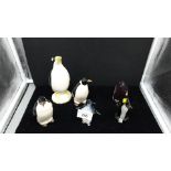 Selection of penguin figures to include art glass .