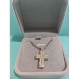 Silver necklace with large thick silver cross set with stones .