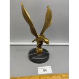 Brass eagle ornament on plinth .