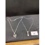 2 silver chains with pendant s one the macintosh design .