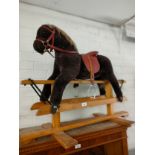 Child's rocking horse on wooden support .