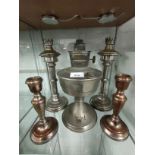 Shelf of plated candle sticks together with oil lamp..