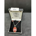 Silver chain with silver pendant set with amber style setting and matching earrings .