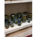 Shelf of Irish wade pottery tankards etc.