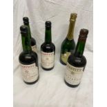 5 vintage bottles of sherry and champagne .