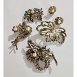 Lot of vintage brooches and earrings with faux pearl settings and detailed designs.