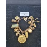 9ct gold Charm bracelet with a large collection of charm to include half sovereign etc . 56 grams .