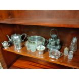 Shelf of silver plated wares .