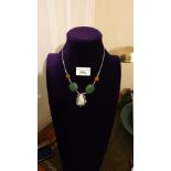 Arts and crafts necklace in silver with Amber stones leading to large green stones then onyx