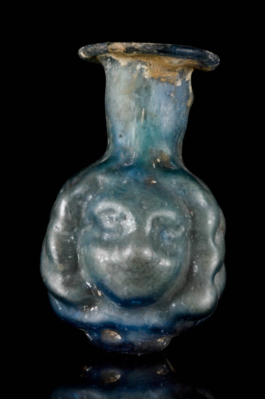 A ROMAN PALE GREEN GLASS JANUS-HEAD SPRINKLER FLASK